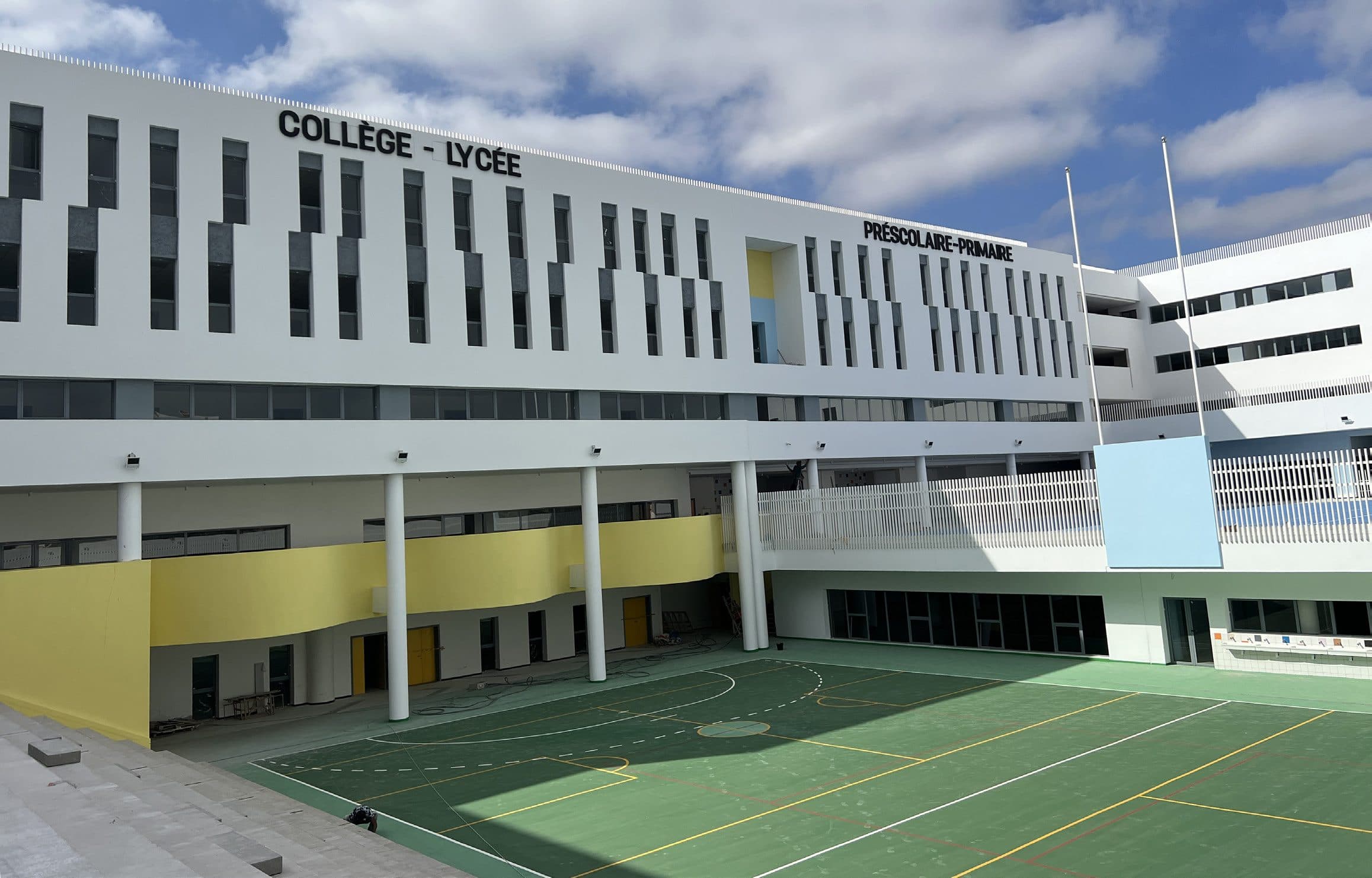 Cour du collège-lycée bordée de préaux jaunes