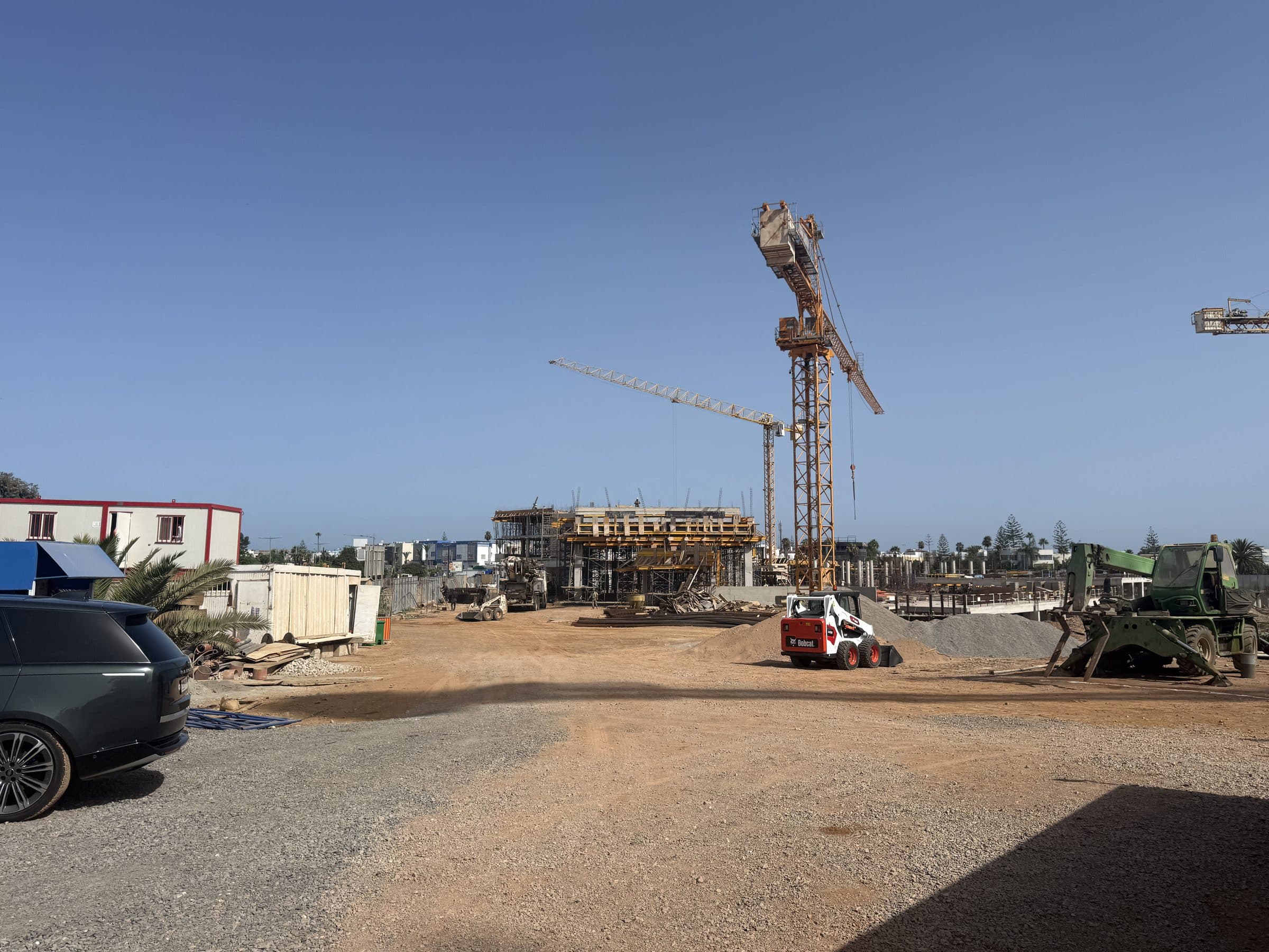 Le chantier et sa grue, vus depuis l’entrée