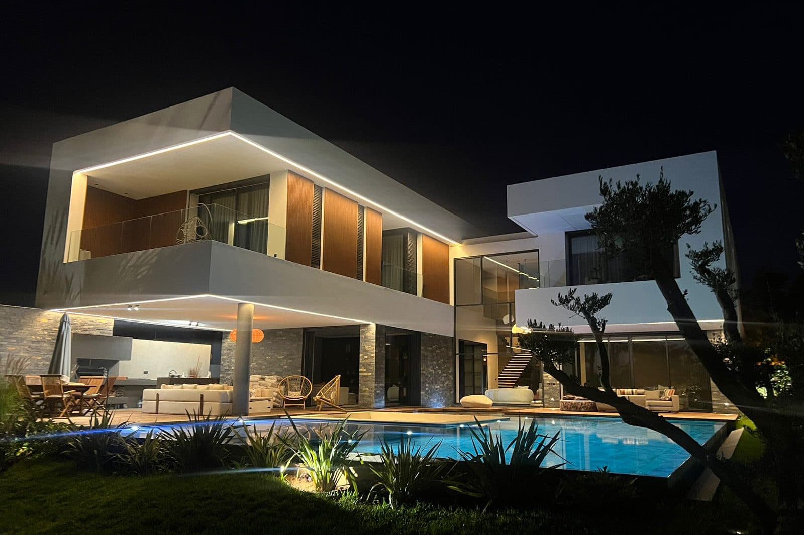 Façade éclairée de nuit et piscine