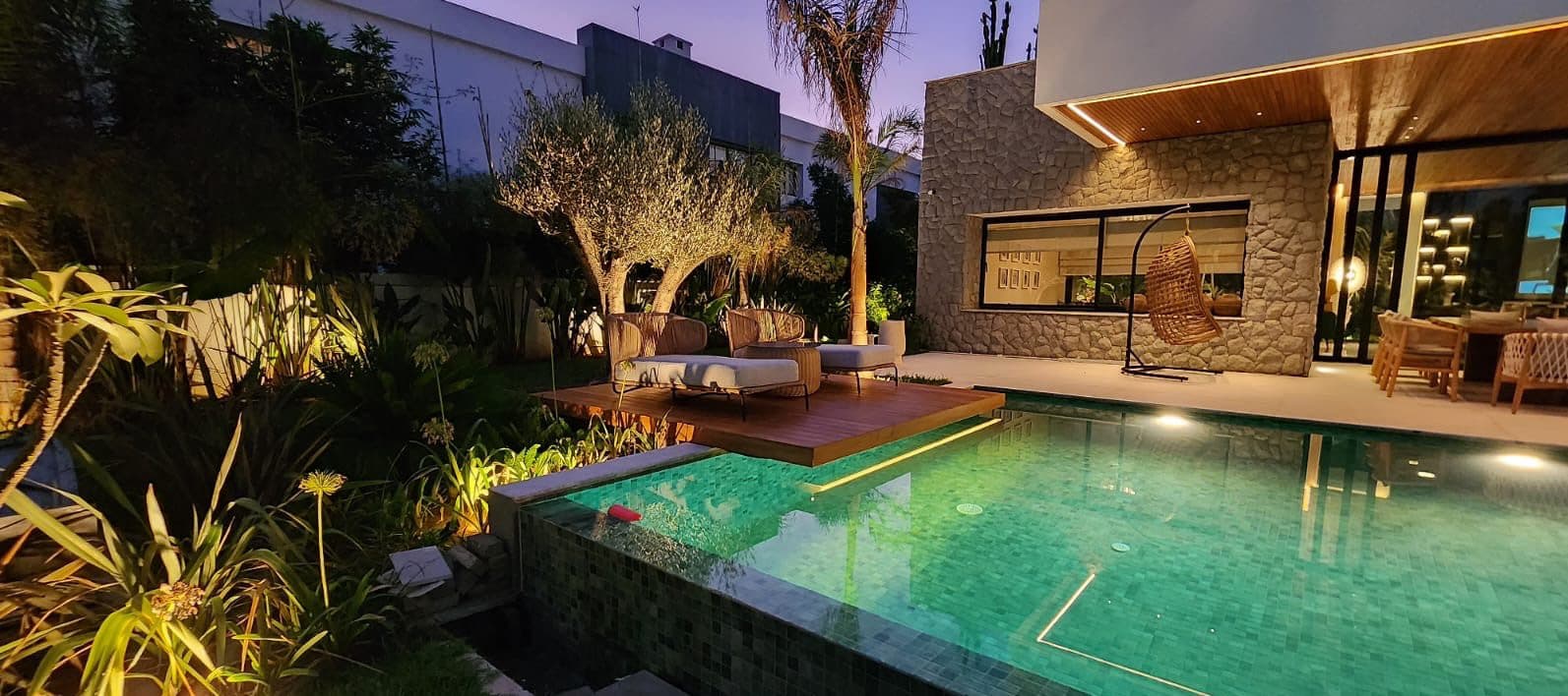 Piscine, terrasse en bois et jardin tropical de nuit