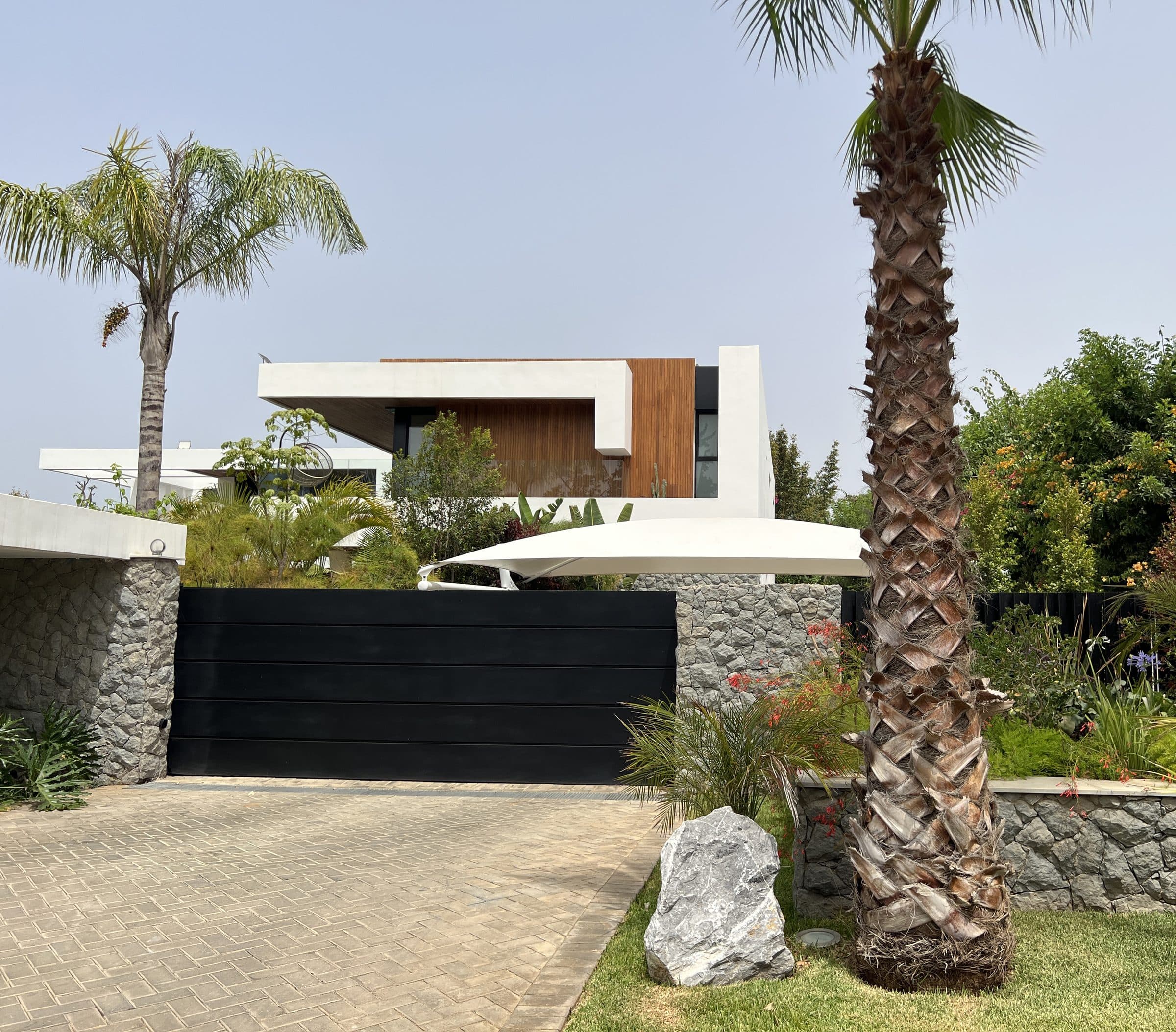 Portail et volumes de la villa depuis la rue